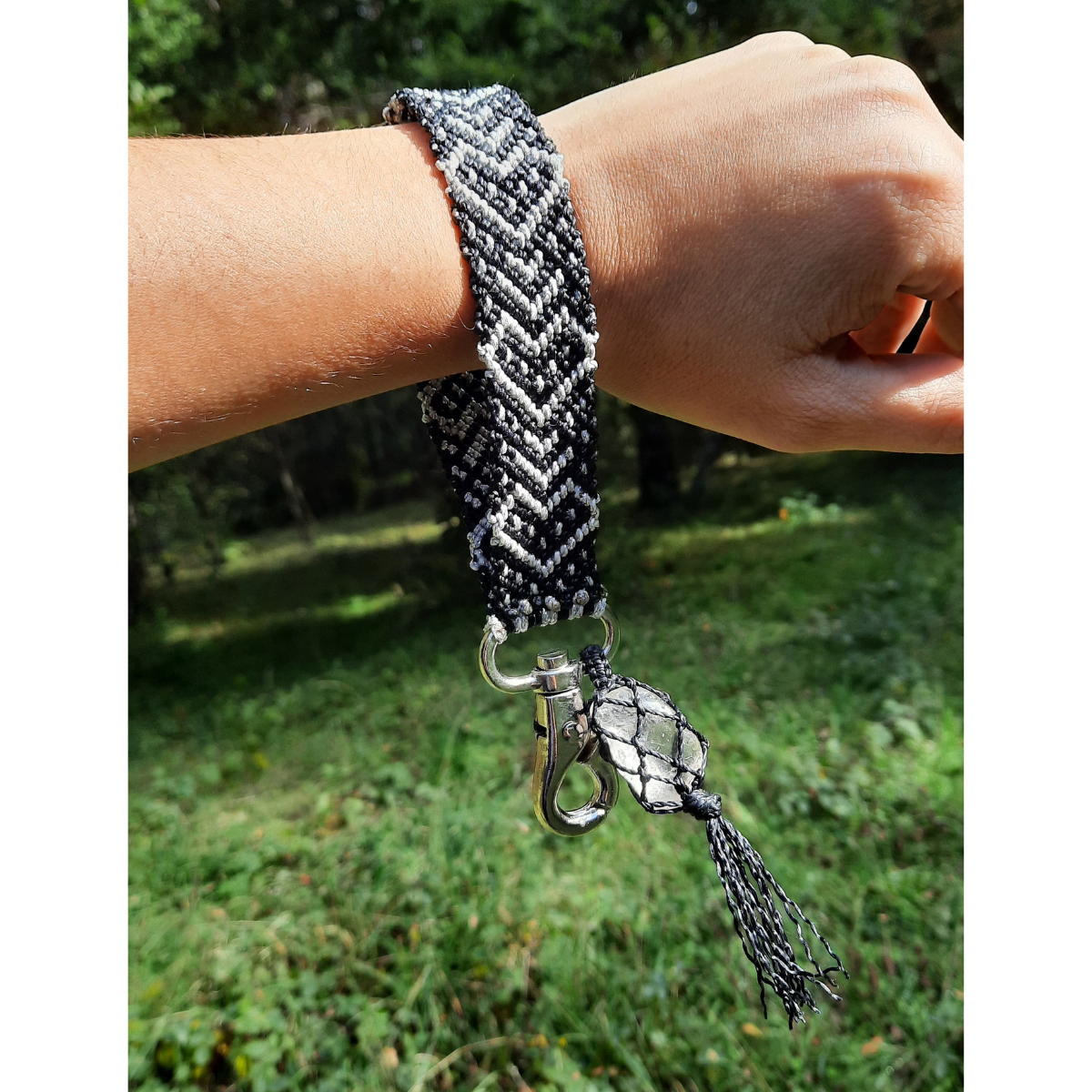 Llavero pulsera de macramé plateado y negro con cuarzo utilizado en la muñeca, tejido artesanal en Pucón.