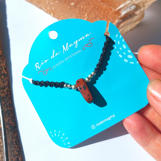 Collar Luz de obsidiana caoba natural con tejido de macramé negro y cuentas de plata 950, sostenido a mano sobre tarjeta de Río de Magma Joyería Artesanal