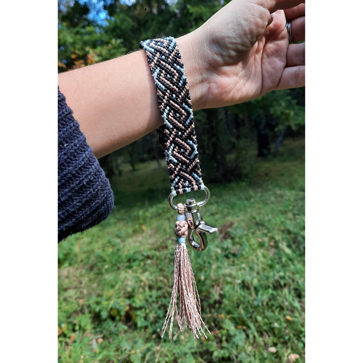 Llavero pulsera de macramé celeste, negro y marrón utilizado en la muñeca, tejido artesanal en Pucón.