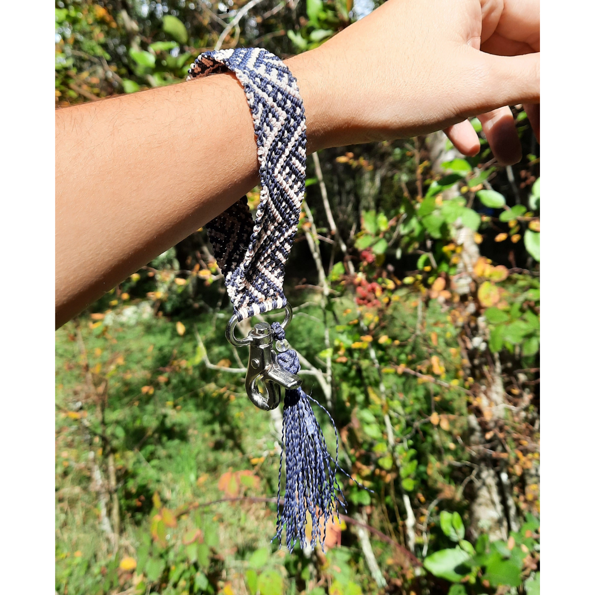 Llavero pulsera de macramé azul marino y rosa claro utilizado en la muñeca, tejido artesanal en Pucón.