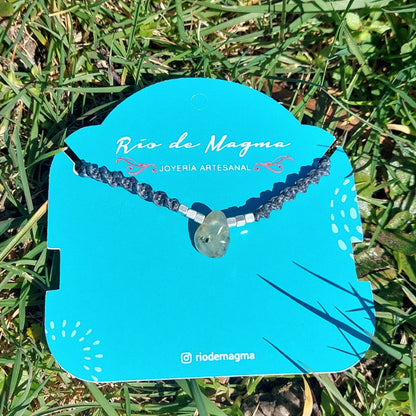 Collar Luz de prehnita natural con macramé gris oscuro y plata 950, presentado sobre tarjeta de Río de Magma Joyería Artesanal