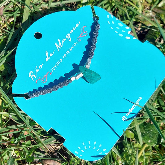 Collar Luz de amazonita natural con tejido de macramé gris oscuro y cuentas de plata 950, vista en ángulo sobre tarjeta de Río de Magma Joyería Artesanal