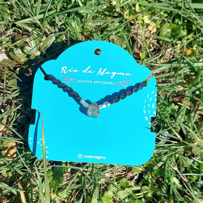 Collar Luz de prehnita natural con tejido de macramé negro y cuentas de plata 950, sobre tarjeta de Río de Magma Joyería Artesanal