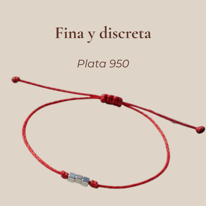 Pulsera delgada roja con cubos de plata 950 con texto 'Hecha a mano' sobre fondo beige