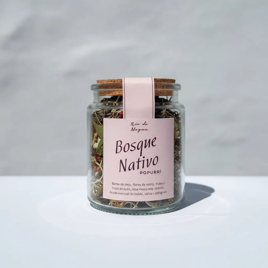 Frasco de vidrio "Bosque Nativo Popurrí – Río de Magma" sobre superficie blanca; interior con mezcla de hierbas y flores secas.